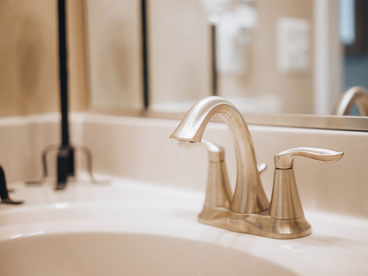 Close-up of a sleek modern bathroom faucet reflecting elegance and luxury.